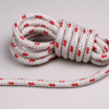 Coiled white double braid polyester sailing rope with red tracers displayed on a neutral background.