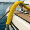 Yellow braided polyester rope cover placed over a grey mooring line on a boat cleat during docking.